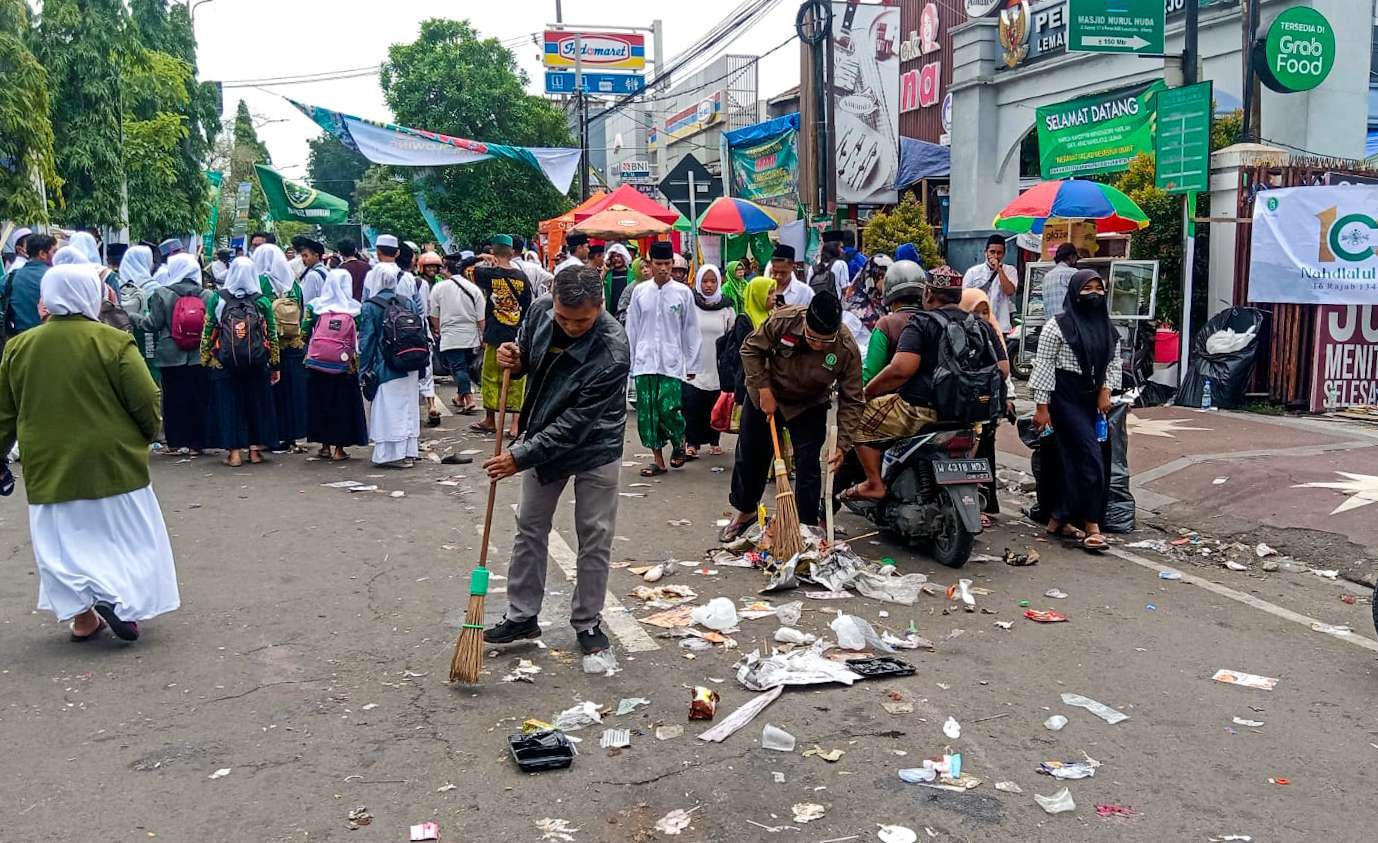 Relawan kebersihan saat menyapu jalan Pahlawan pasca harlah (Foto: Aini/Ngopibareng.id)