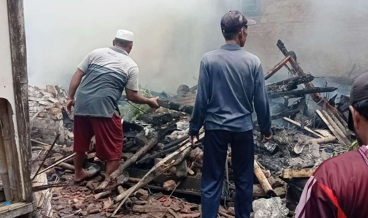 Warga membersihkan puing-puing rumah yang terbakar setelah api berhasil dipadamkan (Foto: Istimewa)