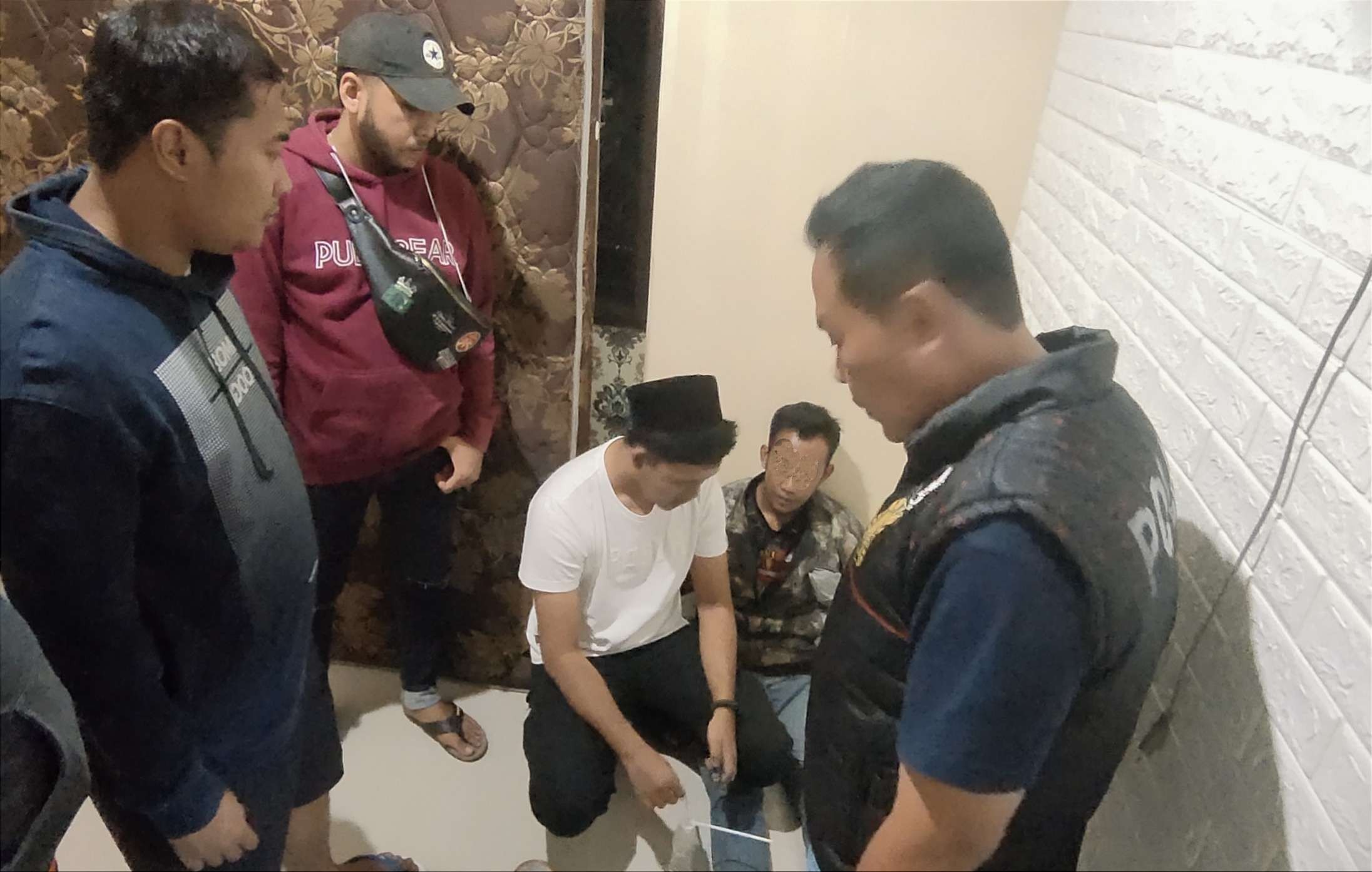 Anggota Satresnarkoba Polres Bondowoso saat menciduk pria pekerja serabutan menghisap sabu di rumahnya.(Foto: Guido/Ngopibareng.id)