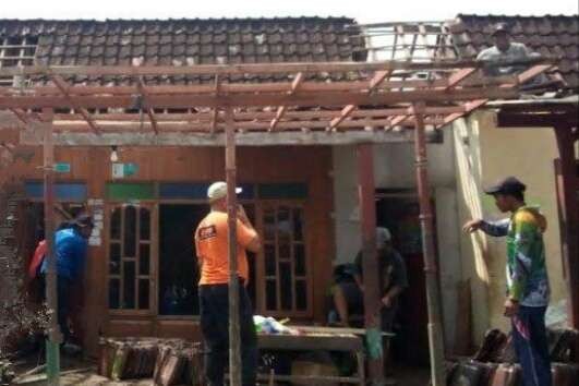 Warga Dusun Krajan, Desa Pasir Putih, Kecamatan Situbondo dibantu anggota BPBD memperbaiki atap rumah rusak diterjang angin kencang.(Foto: BPBD Situbondo)