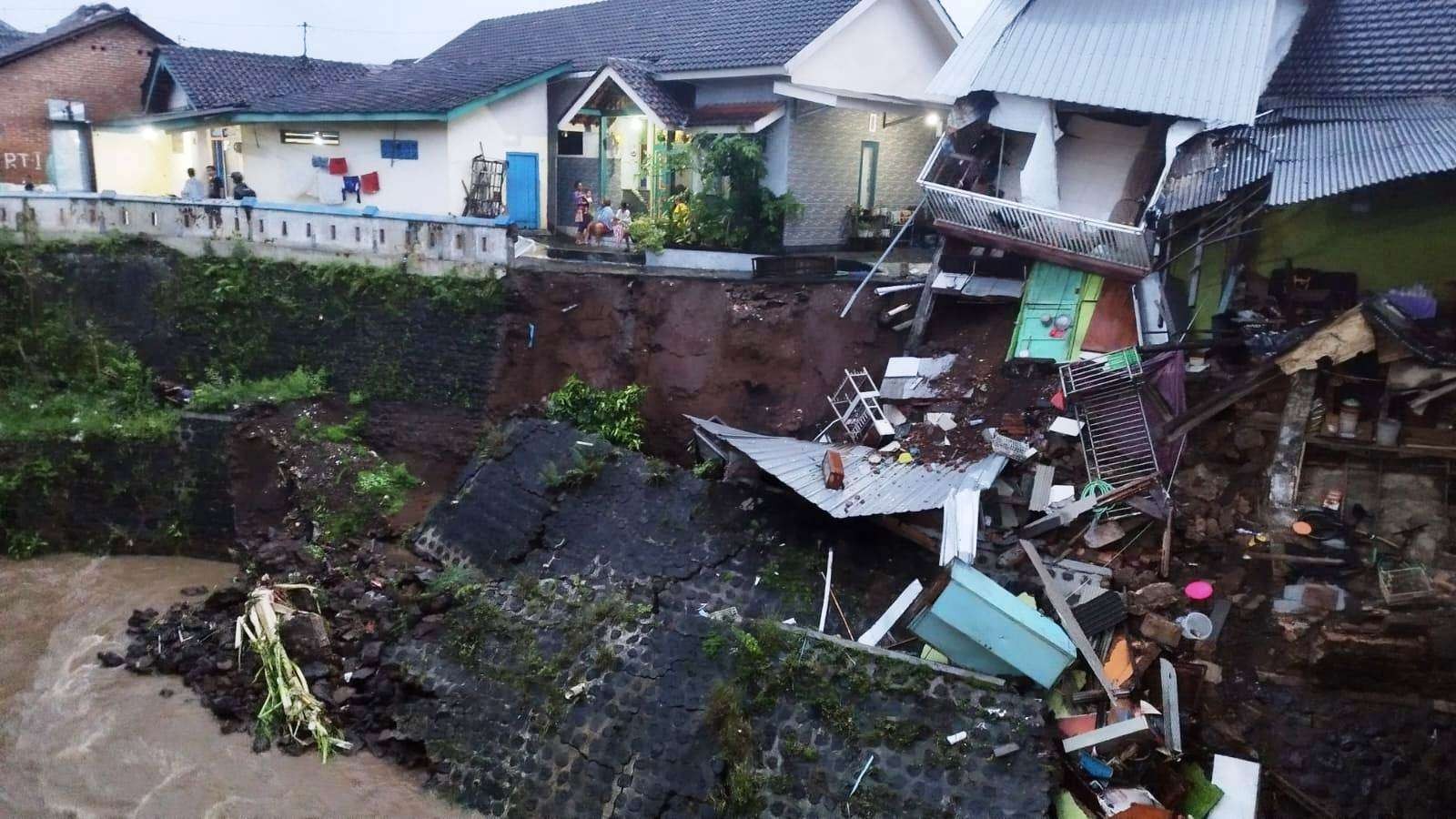 Sebagian rumah warga yang ambruk setelah plengsengan sungai longsor (foto: Muh Hujaini/Ngopobareng.id)