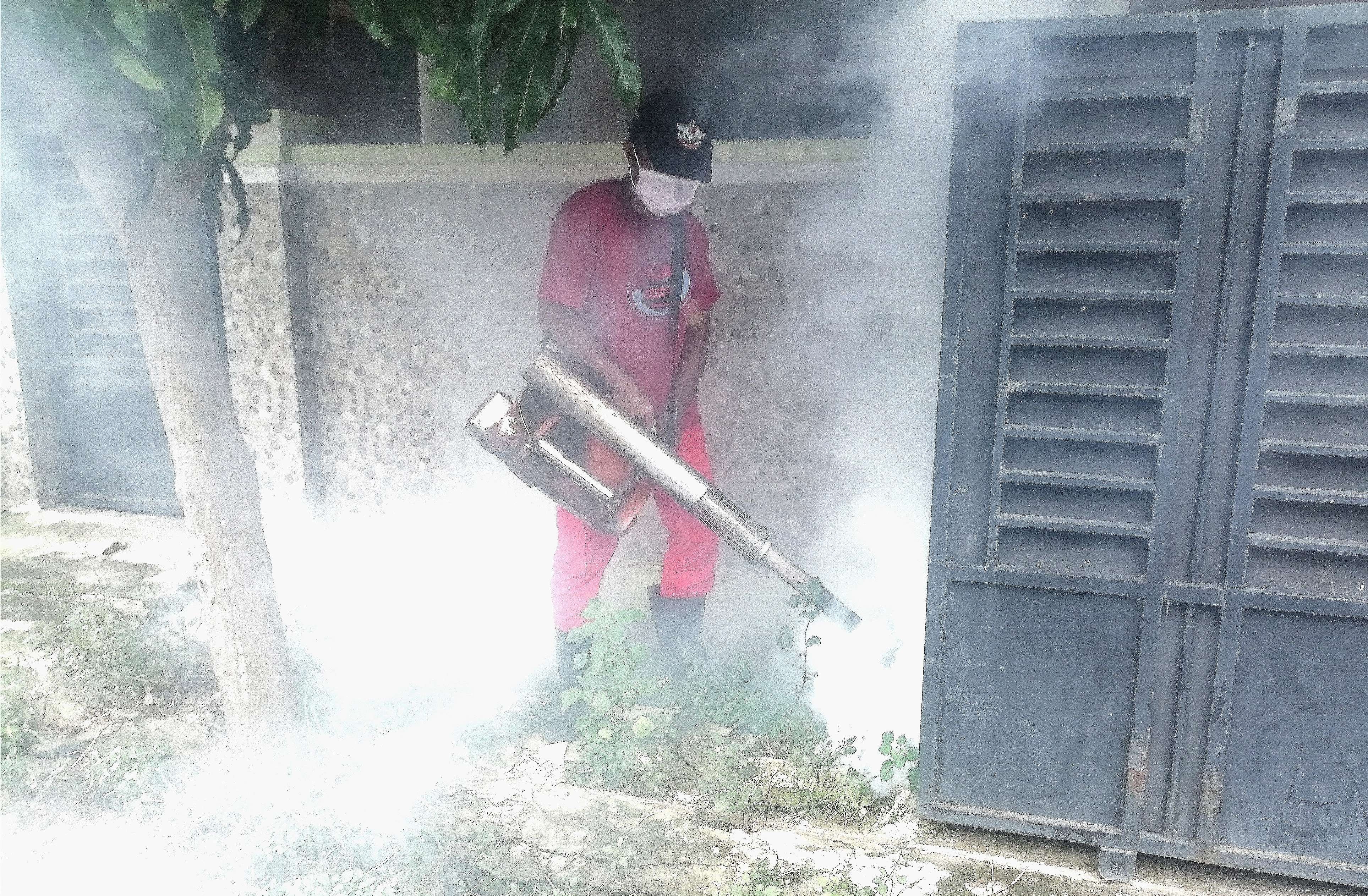 Petugas Dinkes Bondowoso melakukan fogging perumahan di Kecamatan Bondowoso yang ada warganya terserang DBD. (Foto: Guido Saphan/Ngopibareng.id)