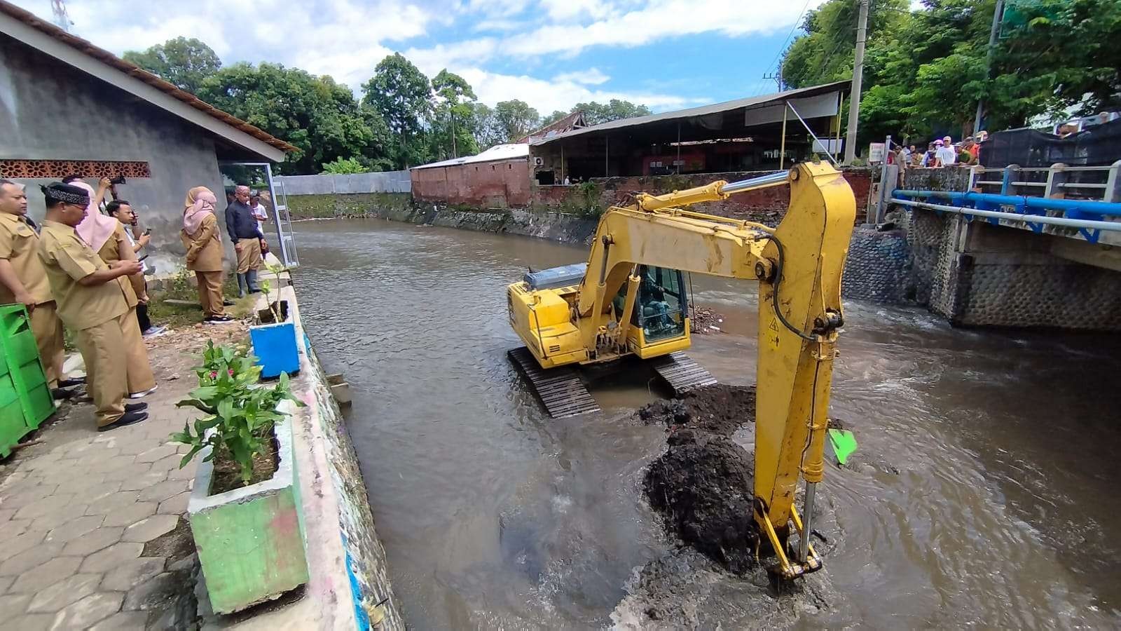 Bupati Banyuwani Ipuk Fiestiandani didampingi Kepala DInas Pengairan Guntur Priambodo melihat proses pengerukan sedimen sungai Kalilo dengan alat berat  (Foto: Muh Hujaini/Ngopibareng.id)