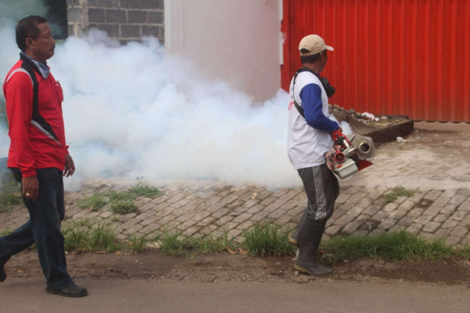 Petugas dari Dinas Kesehatan melakukan pengasapan (fogging) untuk memberantas nyamuk Aedes Aegyti, penyebab DBD. (Foto: Ikhsan Mahmudi/Ngopibareng.id)