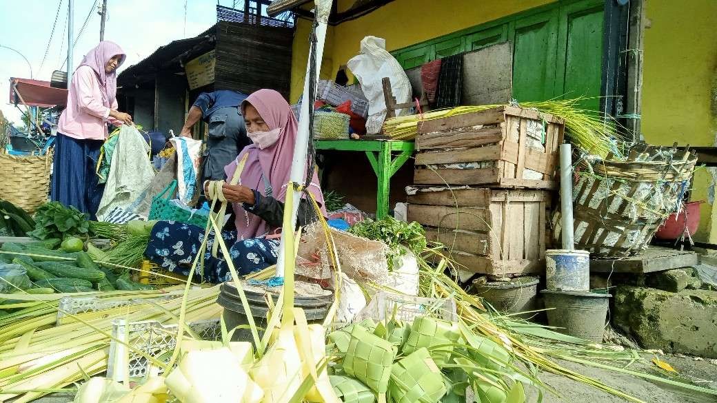 Penjual selongsong ketupat di area pasar baru Tuban saat membuat selongsong ketupat (Foto: Khoirul Huda/Ngopibareng.id)