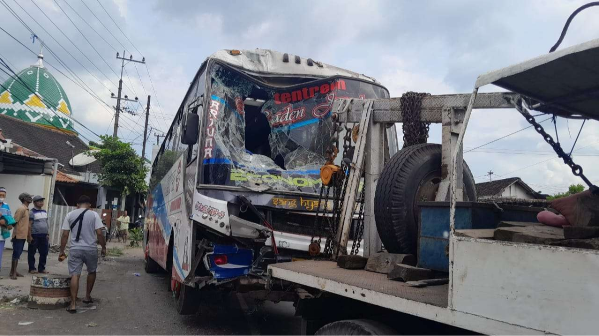 Bus Tentrem diderek setelah menabrak pemotor dan bangunan kosong milik PT. FIF di Jalan Raya Leces, Kabupaten Probolinggo. (Foto: Ikhsan Mahmudi/Ngopibareng.id)