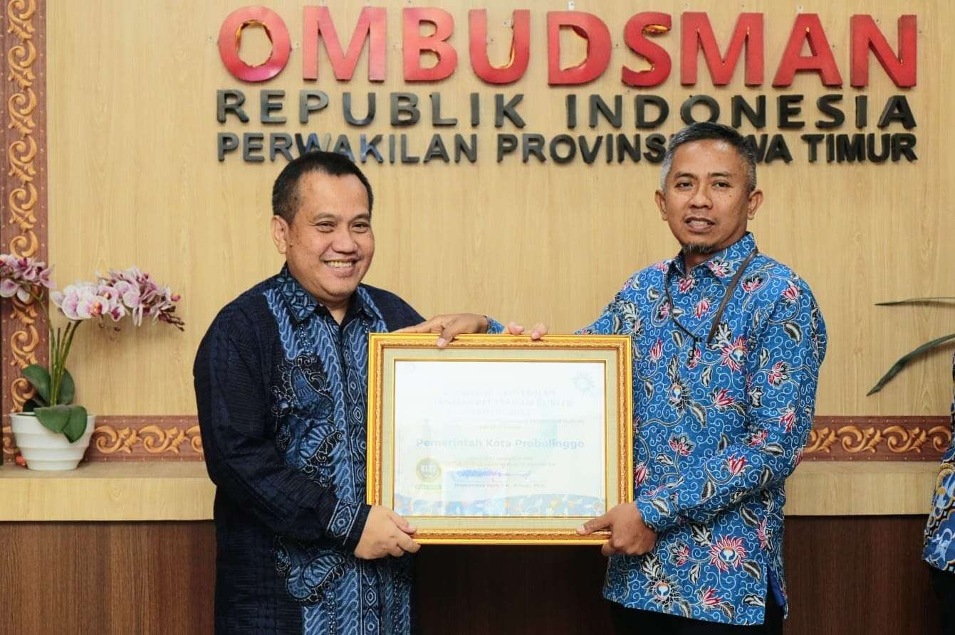 Staf Ahli Walikota Probolinggo Bidang Pemerintahan, Hukum, dan Politik, Agus Hartadi (kiri) menerima piagam penghargaan dari Ombudsman Perwakilan Jawa Timur. (Foto: Diskominfo Kota Probolinggo)