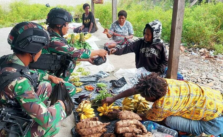 Sembari tugas, prajurit Satgas Yonif Raider 514/SY Bondowoso memborong jualan mama Papua untuk membantu ekonomi masyarakat. (Foto: Penyonif raider 514)