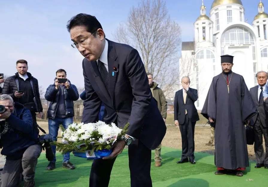 PM Jepang Kishida meletakkan bunga di sebuah gereja di Bucha, tempat kuburan massal warga sipil Ukraina ditemukan tahun lalu. Kishida mengenang warga sipil yang tewas di Bucha, sebuah kota di luar Kyiv. (Foto: AP)