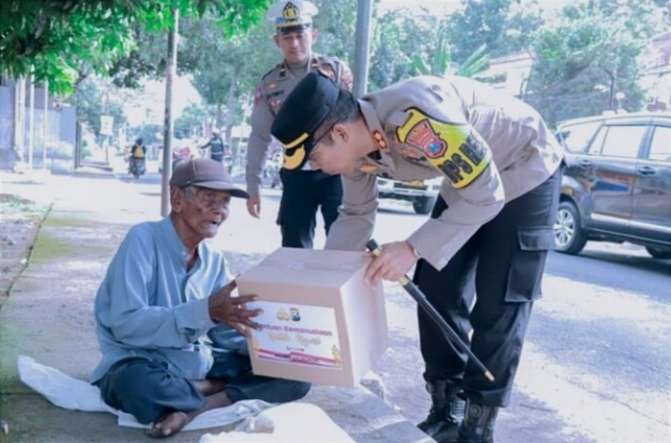 Kapolres Situbondo, AKBP Dwi Sumrahadi memberikan paket sembako kepada seorang pedagang asongan di tepi jalan kota Situbondo, Rabu 29 Maret 2023 siang.(foto: humas polres Situbondo)