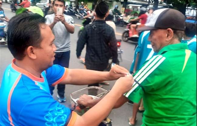 Bolamania Situbondo membagikan pita hitam dengan memasangkanndi lengan pengendara motor sebagai duka mendalam Indonesia batal host Piala Dunia U-20 2023.(Foto: IG Yogie)