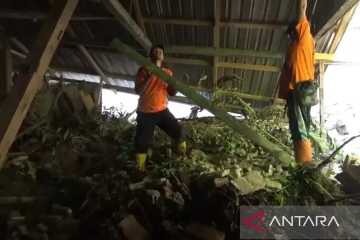 Sejumlah warga dan petugas bergotong royong membersihkan material tanah longsor menimpa rumah warga di Desa Pocol, Kecamatan Sine, Kabupaten Ngawi, Jatim, Jumat (24/3/2031). (Foto. Antara)