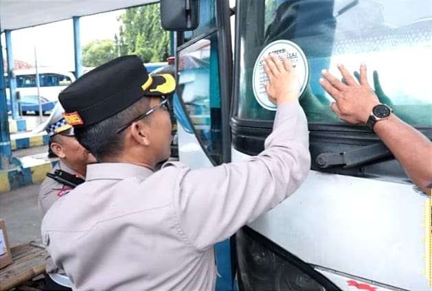 Polisi menempelkan stiker ramdcheck di kaca depan bus angkutan Lebaran 2023 yang sudah pengecekan kelayakan di Terminal Situbondo.(foto: satlantas polres Situbondo)