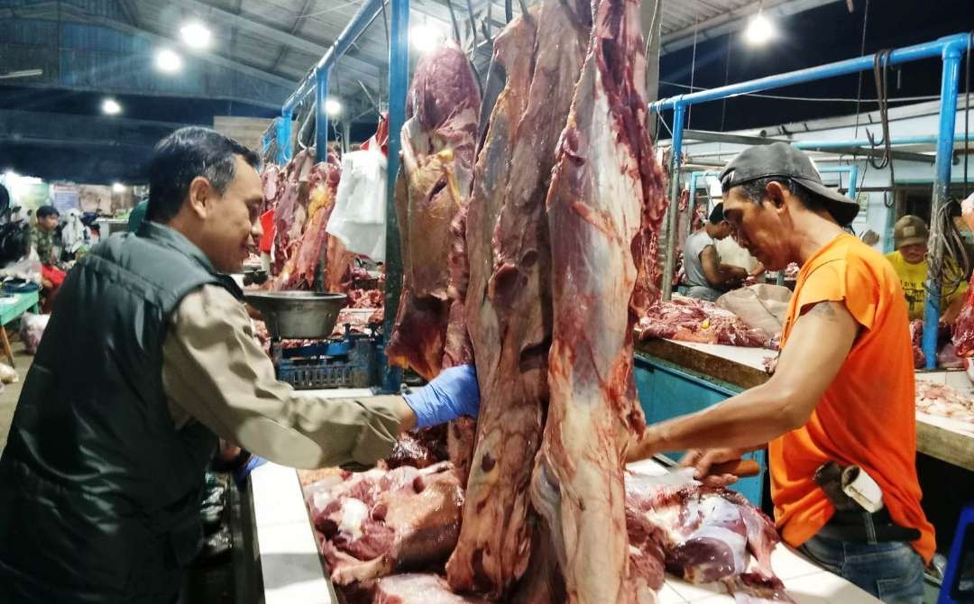 Petugas Dinas Pertanian dan Pangan Banyuwangi mengecek daging yang dijual di pasar Blambangan (foto: istimewa)