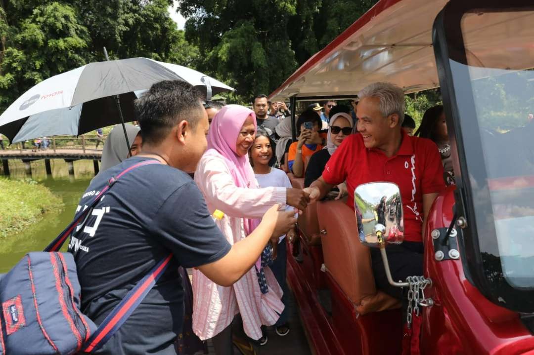 Gubernur Jawa Tengah dan Calon Presiden PDIP Ganjar Pranowo bersalaman dengan warga yang berebut saat mengetahui ada orang nomor satu di Jateng itu di lokasi wisata Solo Safari. (Foto: Humas Pemprov Jateng)