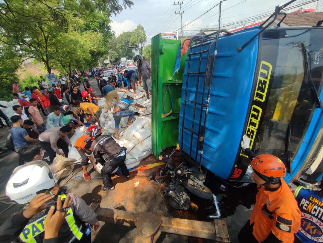 Pemotor tertimpa truk muatan pupuk. (Foto: Deni Lukmantara/Ngopibareng.id)