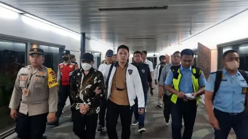 P Hasanuddin berpakaian batik dengan tangan diborgol dibawa penyidik keluar dari ruangan Bandara Soekarno-Hatta menuju Bareskrim Polri untuk menjalani pemeriksaan sebagai tersangka dugaan ujaran kebencian terkait warga Muhammadiyah. (Foto: Ant)