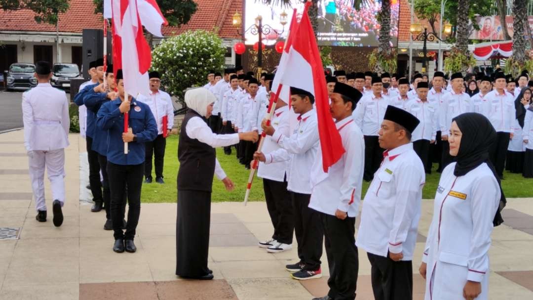 Gubernur Jatim, Khofifah Indar Parawansa saat menyerahkan bendera kepada Petugas Haji saat apel di Gedung Negara Grahadi, Surabaya, Kamis 11 Mei 2023. (Foto: Fariz Yarbo/Ngopibareng.id)