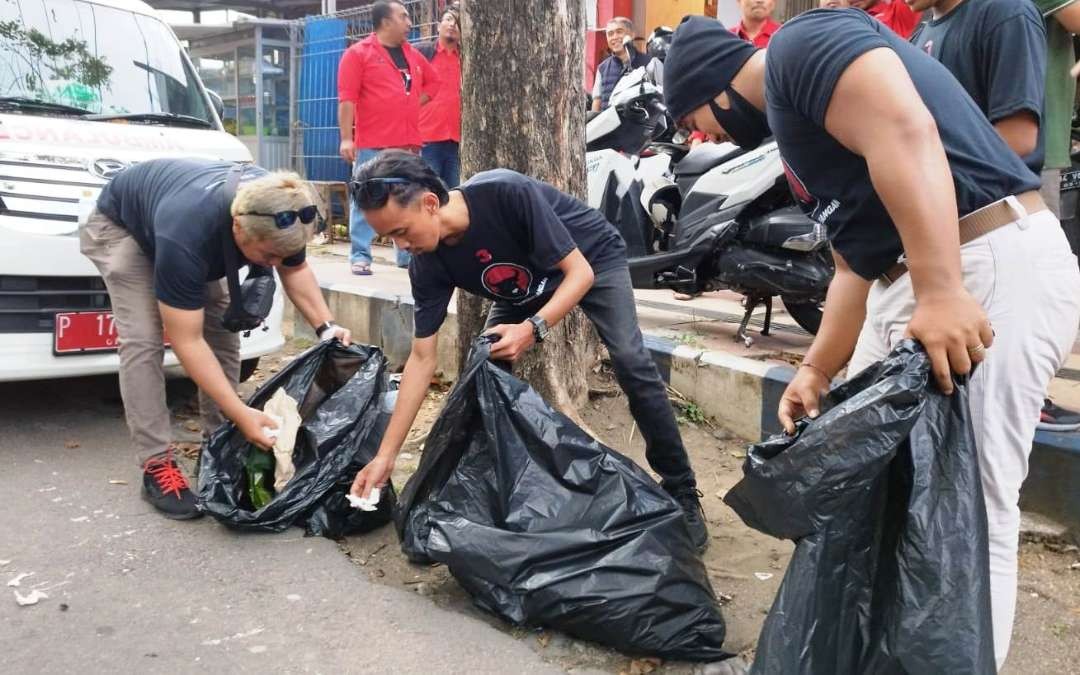 Sejumlah kader PDI Perjuangan mengambil sampah di jalan depan KPU Banyuwangi (foto: Muh Hujaini/Ngopibareng.id)