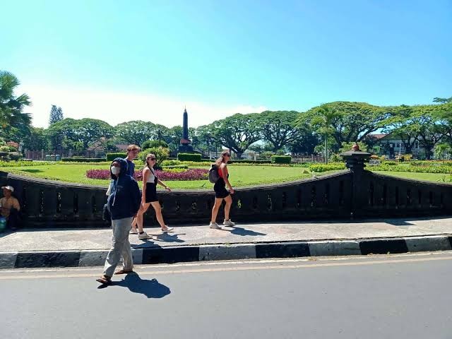Turis asing saat berjalan-jalan di Alun-Alun Merdeka, Kota Malang (Foto: Lalu Theo/Ngopibareng.id)