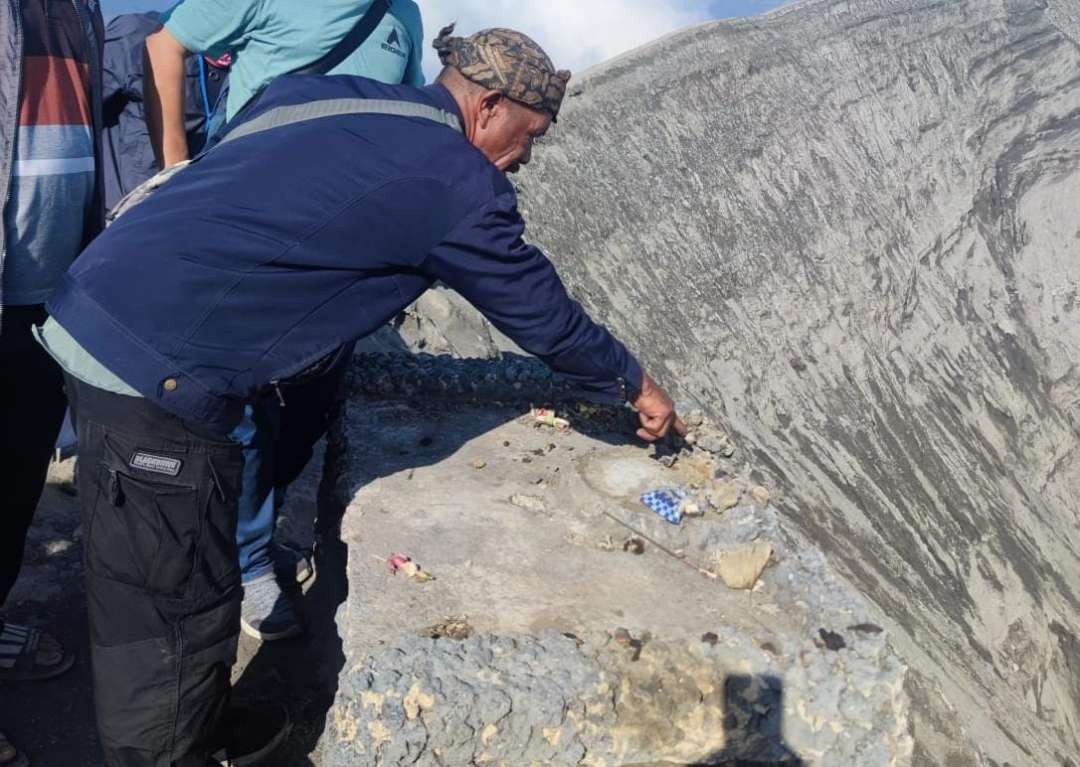 Dukun Tengger menunjukkan lokasi Patung Ganesha yang hilang di bibir kawah Gunung Bromo. (Foto: Polsek Sukapura)