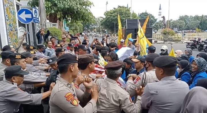 Mahasiswa terlibat aksi saling dorong dengan aparat keamanan dari Polres Tuban, saat melakukan aksi demo di depan Kantor Bupati Tuban. (Foto: Khoirul Huda/Ngopibareng.id)