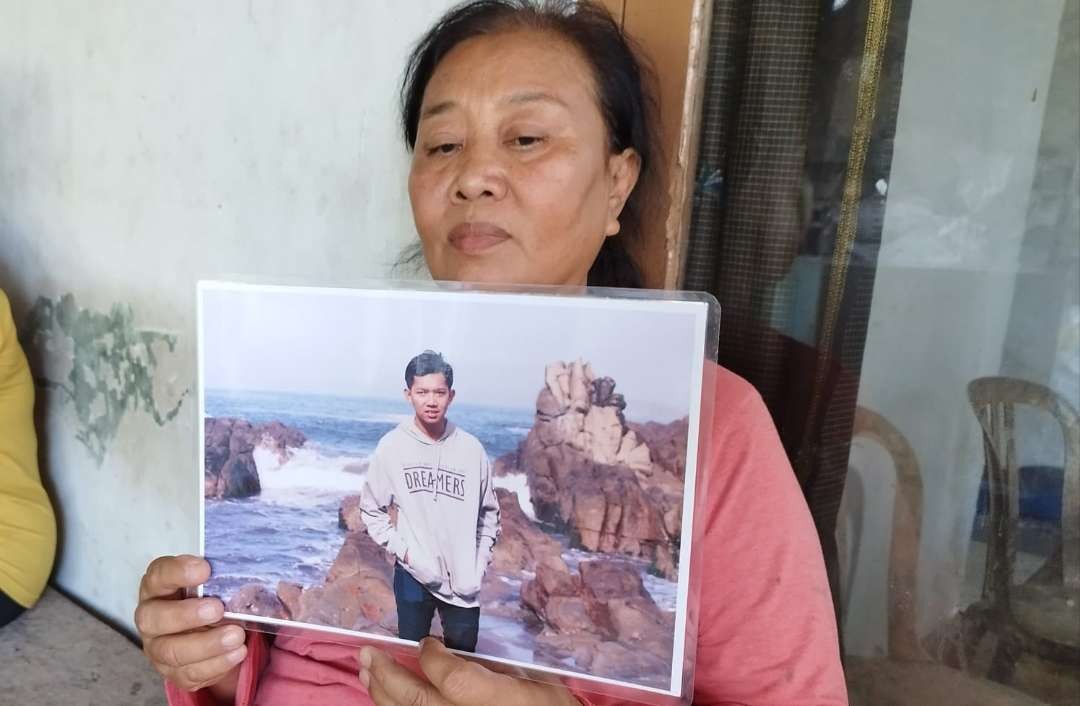 Ibu kandung Ahmad Sugiantoro, Sumini, menunjukkan foto anaknya (Foto; Muh Hujaini/Ngopibareng.id)