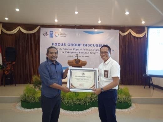 Ketua Umum SBMI, Harianto (kanan) ketika menyerahkan penghargaan kepada Sekretaris Daerah Kabupaten Lombok Timur, Juaini Taofik (kiri) dalam acara  Focus Group Disscusion (FGD) Asesmen Kebijakan Migrasi Pekerja Migran Indonesia (Foto: Pemkab Lombok Timur)