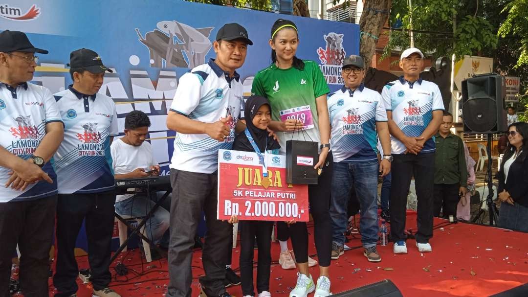 Bupati Yuhronur Efendi menyerahkan medali kepada juara didampingi atlet voli nasional Maya Kurnia Indri yang turut memarakkan Lamongan City Run 2023 (Foto: Imron Rosidi/Ngopibareng.id)