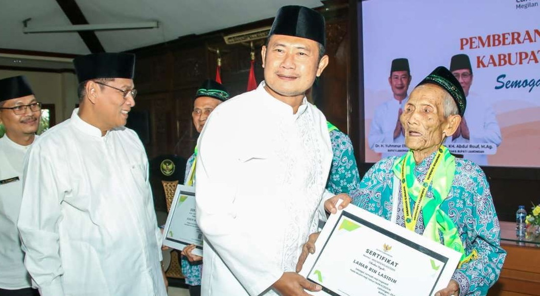 Keterangan Foto : Mbah Lahar saat menerima penghargaan CJH inspiratif dari Bupati Lamongan, Yuhronur Efendi (Foto: Imron Rosidi/ngopibareng.id)