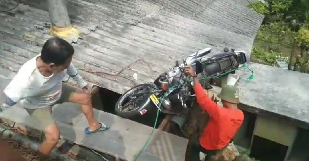Video evaluasi sepeda motor nyangkut diatap rumah warga.(foto istimewa)