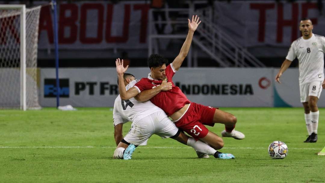 Pemain Timnas Indonesia, Rafael Struick (merah) mendapat hadangan pemain Palestina dalam laga FIFA Matchday di Stadion Gelora Bung Tomo, Surabaya, Rabu 14 Juni 2023. (Foto: Fariz Yarbo/Ngopibareng.id)