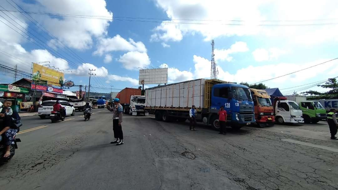 Petugas Polsek Kawasan Pelabuhan Tanjungwangi tampak mengatur arus lalu lintas di depan pintu masuk Pelabuhan  Ketapang (Foto : Muh Hujaini/Ngopibareng.id)