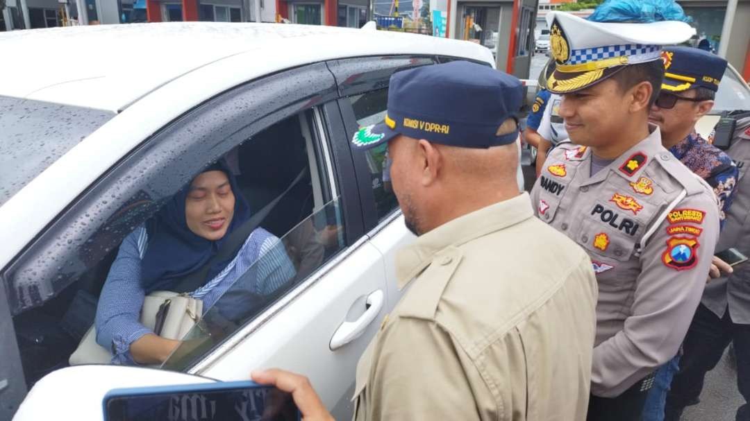 Anggota Komisi V DPR RI Sumail Abdullah menyapa salah seorang pengguna jawa penyeberangan yang antre di Pelabuhan Ketapang (foto:Muh Hujaini/Ngopibareng.id)