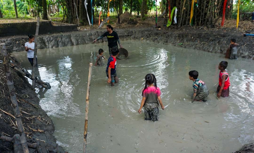 Anak-anak menangkap ikan di kubangan lumpur di Kampung Lali Gadget Sidoarjo (foto : Aini/Ngopibareng.id)
