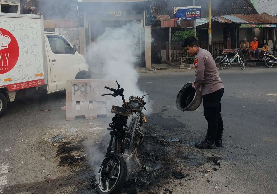 Petugas kepolisian memadamkan api yang membakar motor di simpang tiga Desa Sambonggede, Kecamatan Merakurak. (Foto: Dokumentasi Polres Tuban)