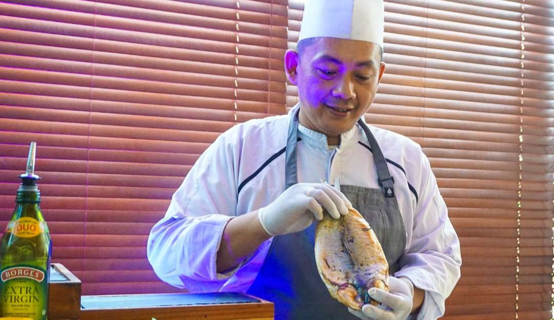 Chef Danu menunjukkan ikan bandeng yang telah diasapi menggunakan oven (foto : Aini/Ngopibareng.id)