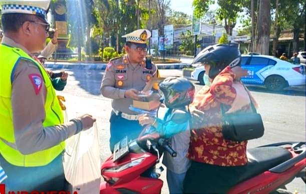 Ibu pengendara motor dan anaknya memakai helm menerima hadiah telur dan minyak goreng dari Satlantas Polres Bondowoso saat Operasi Patuh Semeru 2023.(Foto:Istimewa))