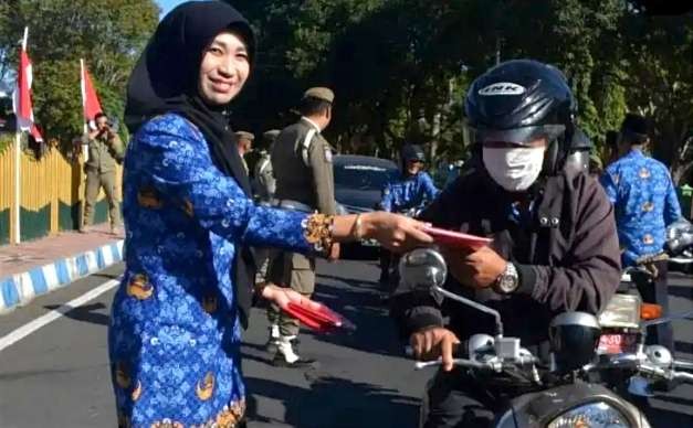 Asisten I Pemkab Bondowodo, Haeriyah Yuliati membagikan bendera Merah Putih kepada pengendara motor, Senin 17 Juli 2023.(Foto: Istimewa)