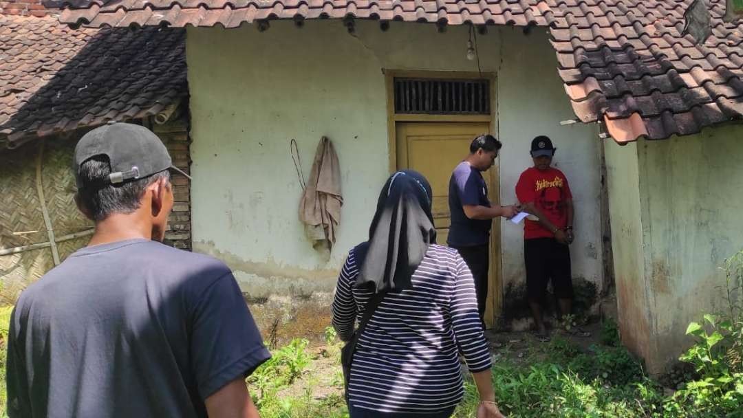 Tersangka berbaju merah saat diminta menunjukkan rumah kosong yang dijadikan tempat saat memperkosa korban (Foto: Dok Polsek Jenggawah)