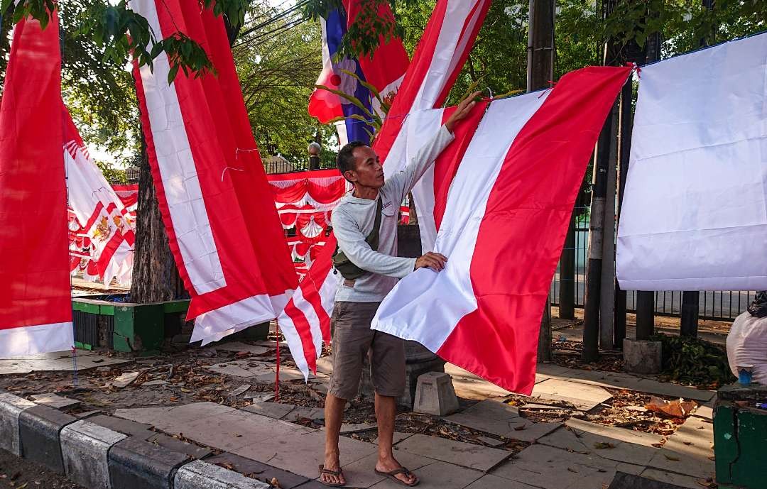 Asep, pedagang bendera Agustusan di Sidoarjo, Jawa Timur. (Foto: Aini Arifin/Ngopibareng.id)