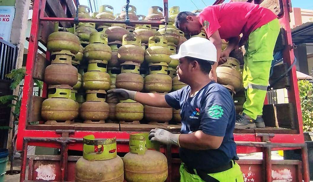 Petugas sedang menurunkan elpiji 3 kg dari truk ke sebuah pangkalan. (Foto: Muh Hujaini/Ngopibareng.id)