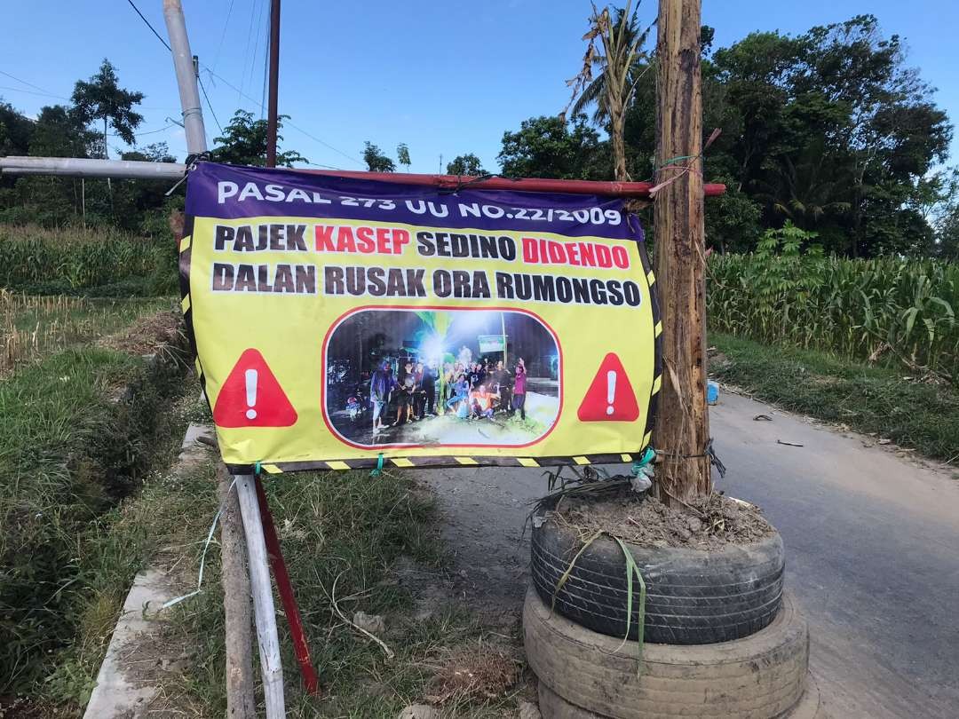 Warga Desa Bangle Kecamatan Kanigoro, Kabupaten Blitar menggelar aksi tanam pohon pisang dan bubuhkan tanda tangan, menuntut perbaikan jalan pada Selasa 25 Juli 2023. (Foto: Choirul Anam/ngopibareng.id)