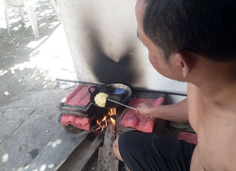 Hary Sutandoko menggoreng telur dengan kayu bakar di tungku yang dibuat dari genting bekas. (Foto: Istimewa)