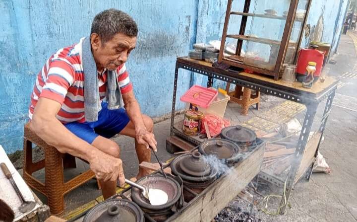 Supii memasak kue serabi secara tradisional menggunakan kayu bakar, bisa langsung dinikmati di tempat. (Foto: Asmanu Sudharso/Ngopibareng.id)
