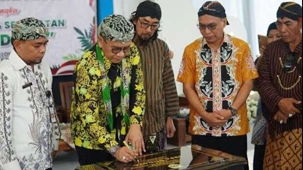 Sekda Bondowoso, Bambang Sukwanto menandatangani batu prasasti Desa Budaya Karang Melok, Kecamatan Tamanan, Bondowoso, Jawa Timur. (Foto: Guido Saphan/Ngopibareng.id)