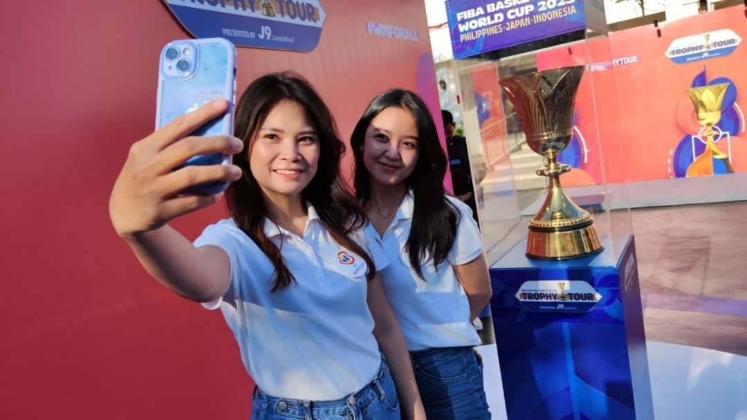 Warga memanfaatkan momen kehadiran Trophy FIBA World Cup 2023 untuk berfoto di Balai Pemuda, Surabaya, Rabu 2 Juli 2023. (Foto: Fariz Yarbo/Ngopibareng.id)