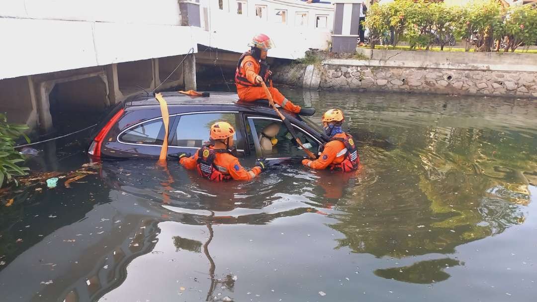 Petugas PMK Surabaya melakukan proses evakuasi mobil tercebur dalam sungai di Jalan Kalisari, Surabaya, Kamis 3 Agustus 2023. (Foto: Command Center 112)