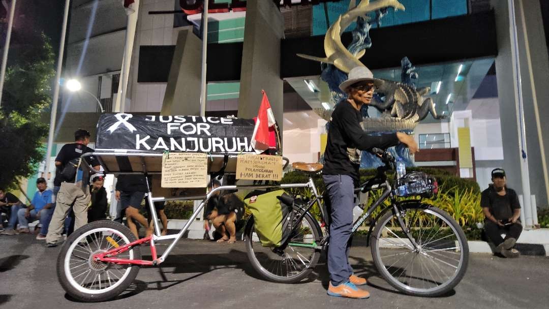 Miftahiddun Ramly alias Midun dengan sepedanya tiba di Stadion Gelora Bung Tomo, Surabaya, Jumat 4 Agustus 2023 malam. (Foto: Fariz Yarbo/Ngopibareng.id)