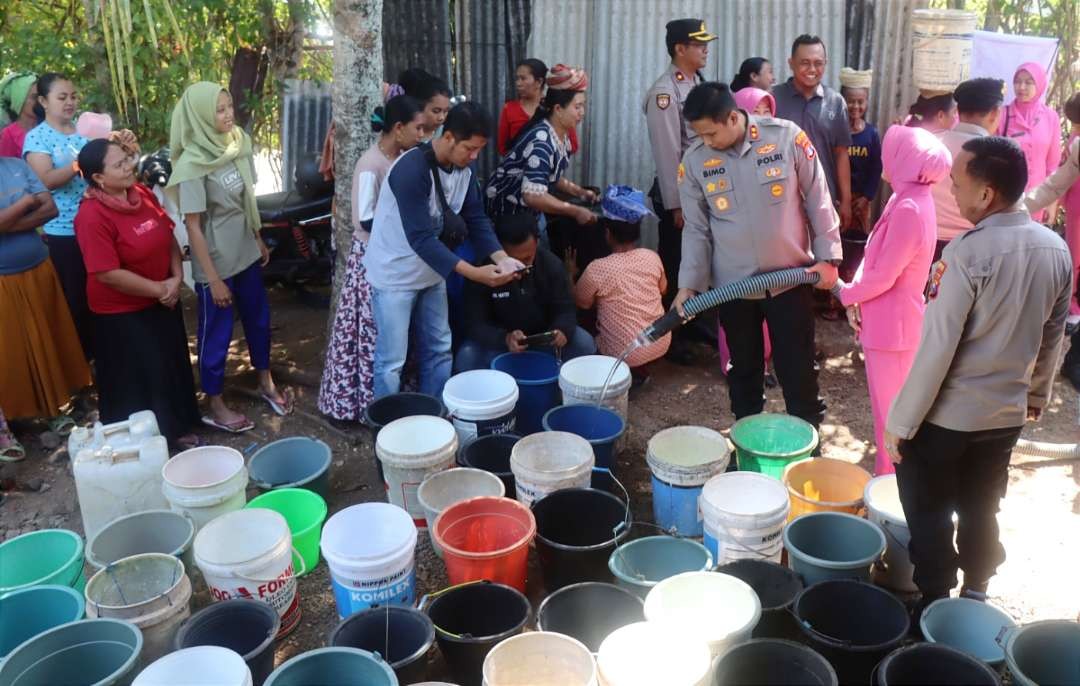 Warga Desa Purnama Kecamatan Tegalampel terdampak kemarau panjang mendapat bantuan 20 liter air bersih dari Polres Bondowoso, Jawa Timur, Kamis 10 Agustus 2023. (Foto: Guido Saphan/Ngopibareng.id)